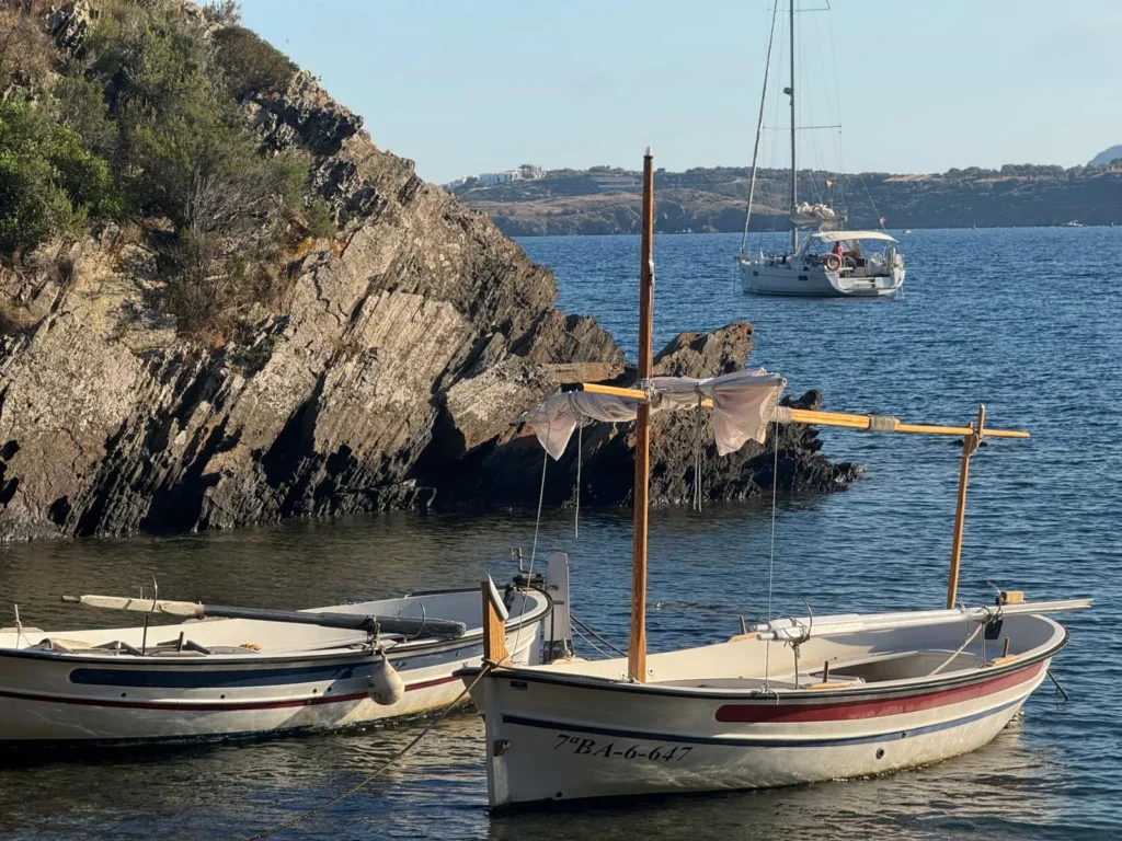Llaüts tradicionales y velero fondeado en Cala Guillola, junto a Portlligat (Cap de Creus, Costa Brava)